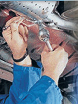 mechanic welding an exhaust